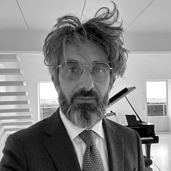 Black and white portrait of Francesco Mariano, grand piano in the background